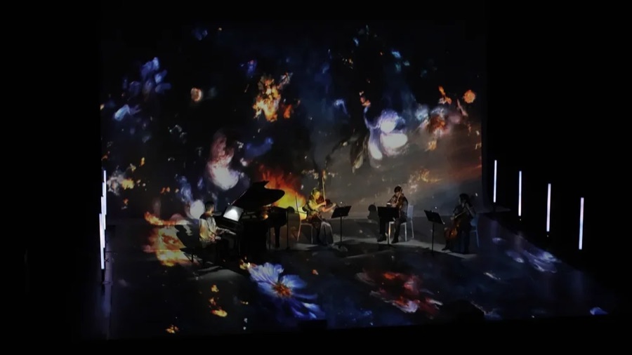 Musicians playing inside projected night flowers